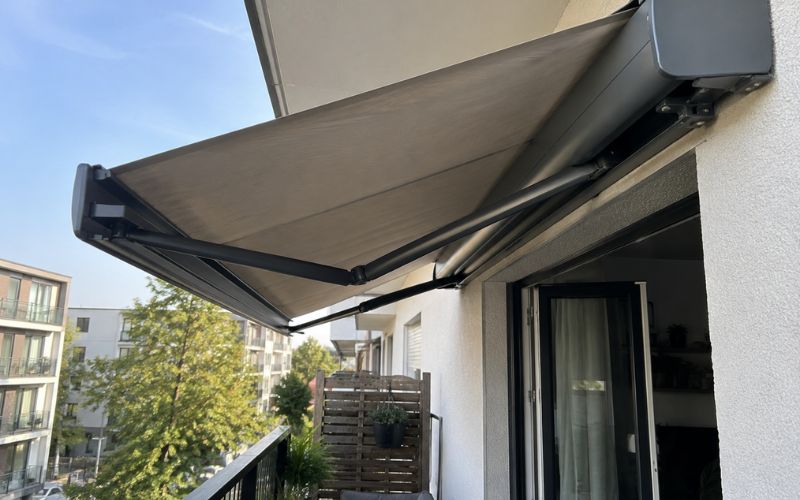 Markiza balkonowa w kasecie zamontowana nad wyjściem na balkon w bloku